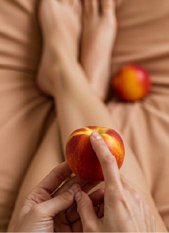 Mujer sensual sosteniendo un durazno con ambas manos, enfoque en la fruta.Mujer sensual sosteniendo un durazno con ambas manos, enfoque en la fruta.
